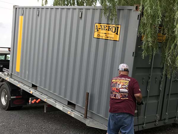 Man Unloading A-Verdi Storage Container Off Truck