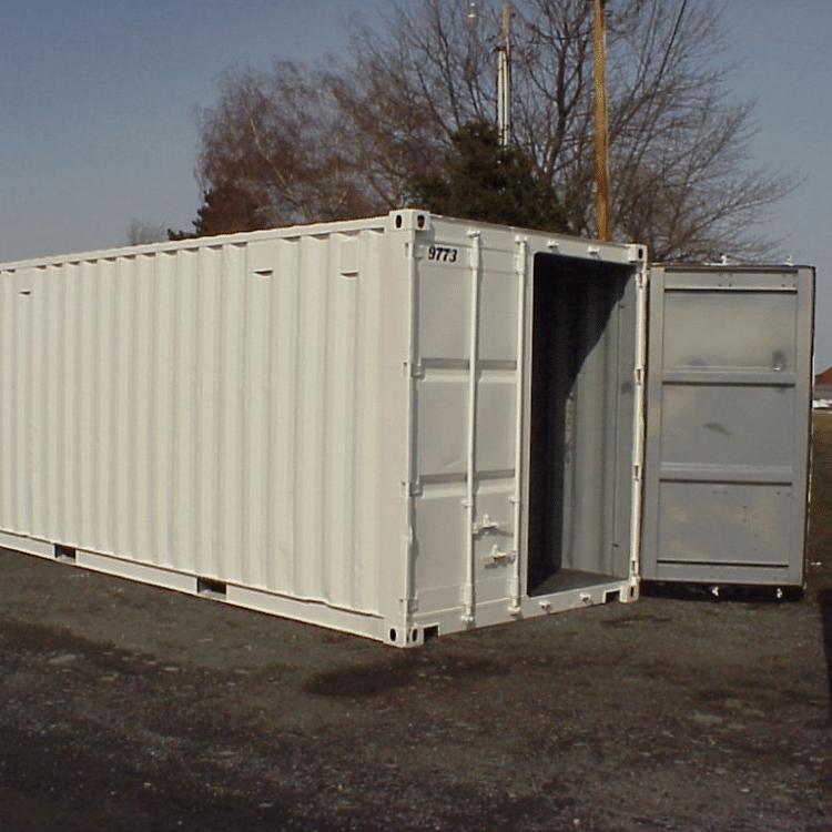 A white portable storage container with one of its doors fully open, placed on a gravel lot. The container is clean and freshly painted, with trees and utility poles visible in the background.