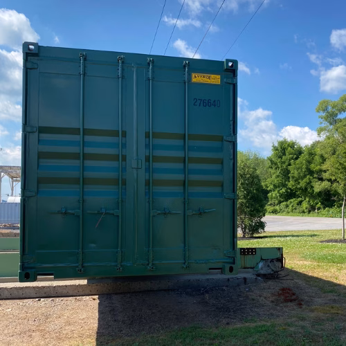 Green A-Verdi storage container placed on-site for rent-to-own use.