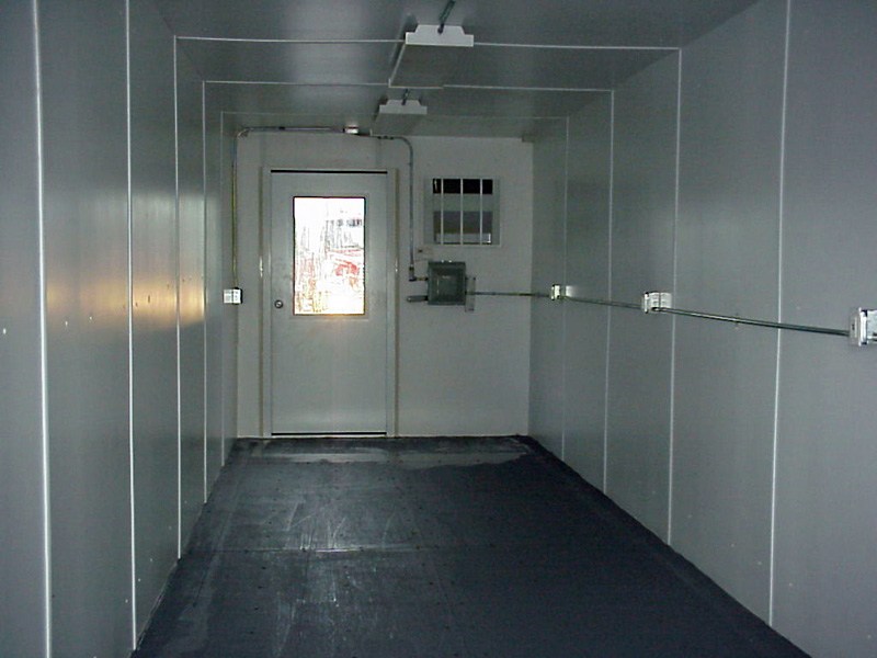 Modern A-Verdi office container interior featuring finished walls, overhead lighting, electrical outlets, and a secure entry door, providing a comfortable and functional on-site workspace