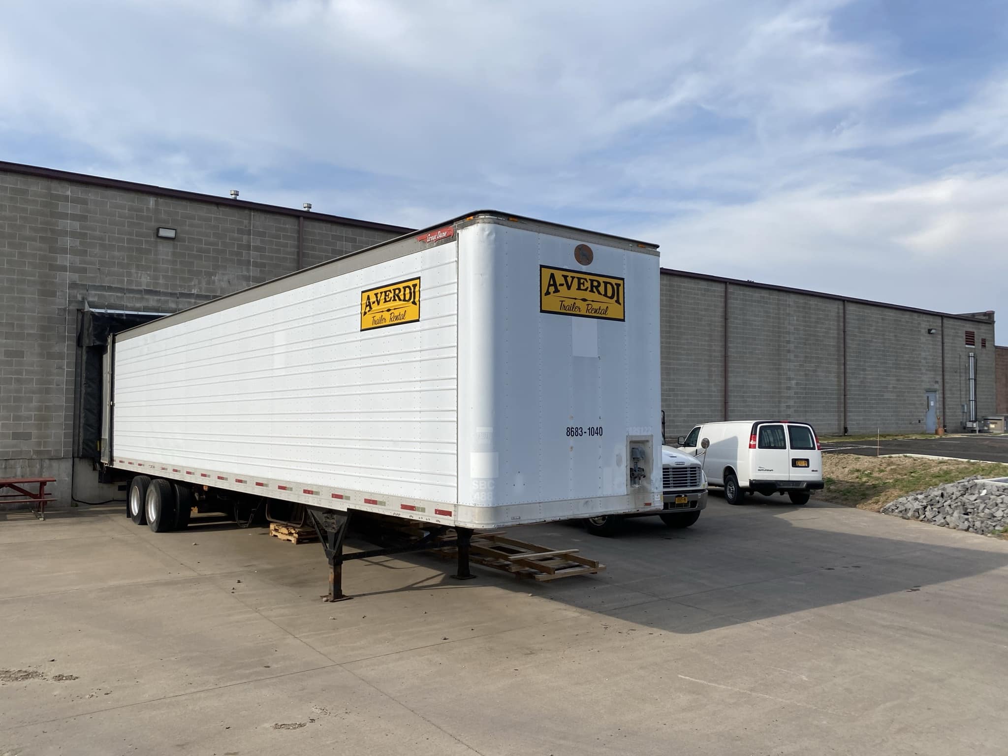 A-Verdi trailer rental parked at a warehouse loading dock for storage or transport use.