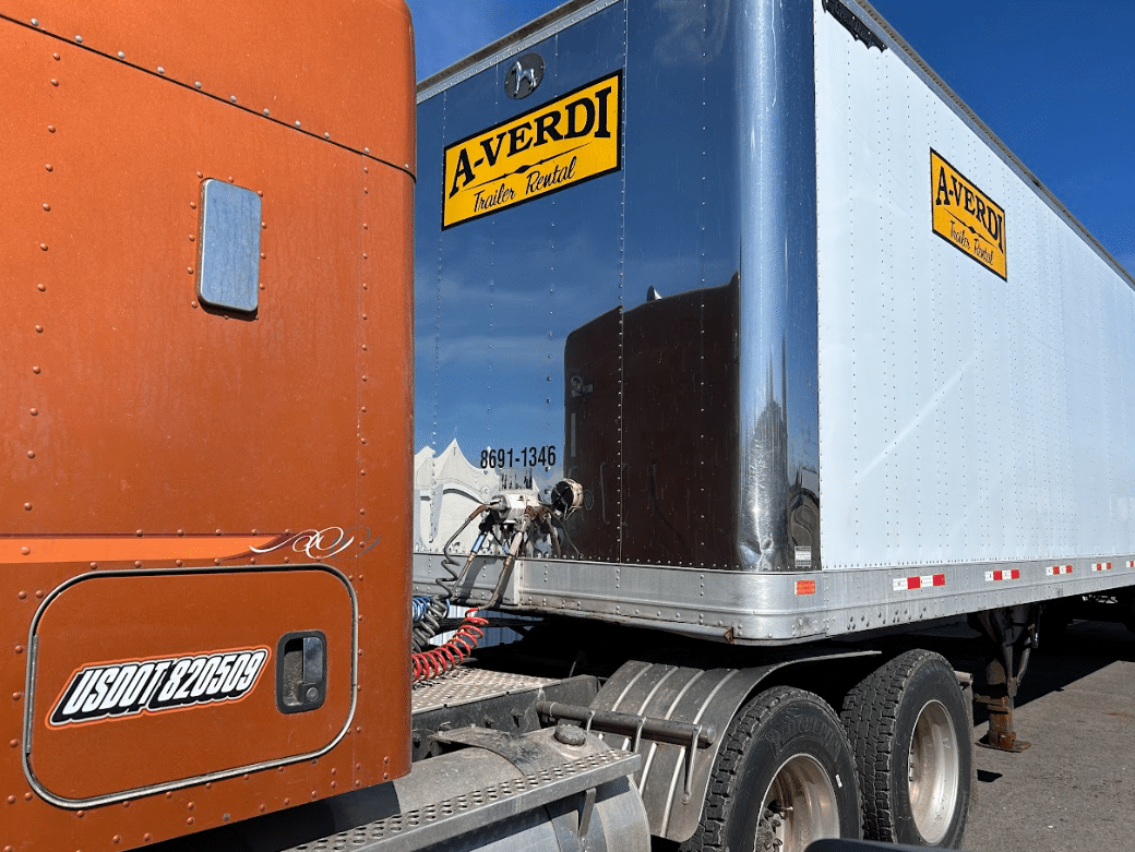 A-Verdi trailer rental attached to an orange semi-truck, ready for transport.